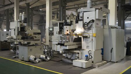 Metalworking milling machine. Produces metal detail in a factory. Machine tools for metal working. A metal workpiece is machined by an electric machine. Cutting metal modern processing technologyの写真素材