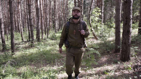Hunting hunter men with gun walking through forest during hunting season. Man hunter outdoor in...