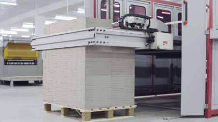 Conveyor line for the production of boxes. Machine carves and bends cardboard boxes from sheets of...