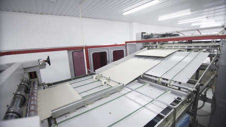 Conveyor line for the production of boxes. Machine carves and bends cardboard boxes from sheets of...