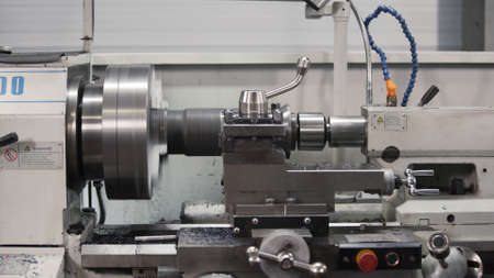 Metalworking milling machine. Produces metal detail in a factory. Machine tools for metal working. A metal workpiece is machined by an electric machine. Cutting metal modern processing technologyの写真素材