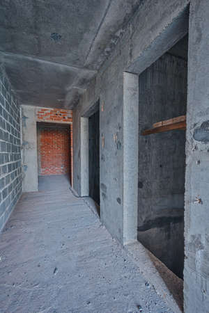 Empty concrete elevator shaft in building. Walls are not plastered. Repair works on construction site of residential apartments. Hallway in new building without repair.の写真素材