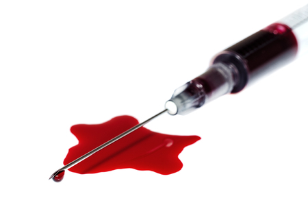 Syringe with blood as a concept of donationの写真素材