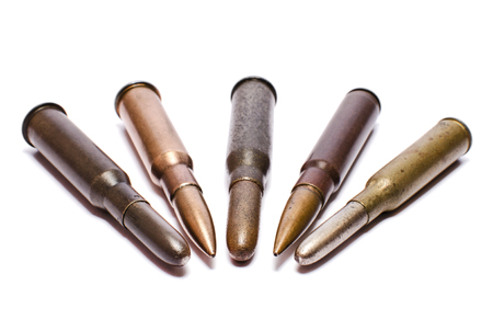 The old rifle cartridges on white surface. Concept of weapon and military equipment.の写真素材
