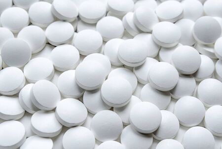 Round white tablets close up. Healthcare and medicine
