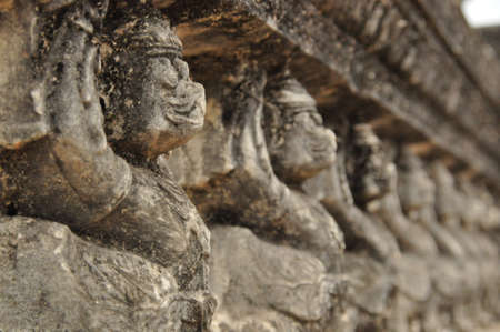 antique statue of prayer on wall carvingの写真素材