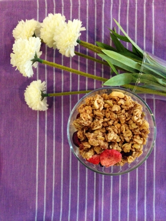 Close up of red berry granola in a jar and flowers backgroundの素材