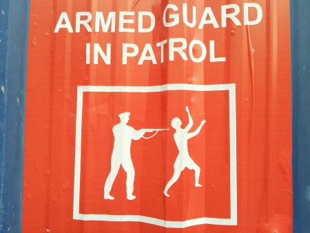 Armed guard in patrol warning sign の素材