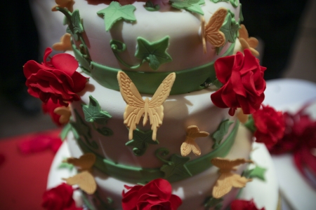 Close up shot of 3 tier wedding cake with roses and butterflies の写真素材