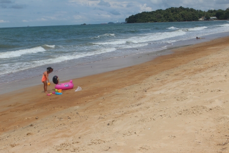 Little girl playing with pink float at Port Dickson beachのeditorial素材