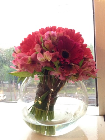 Beautiful daisies arranged in a clear vase at office windowの素材