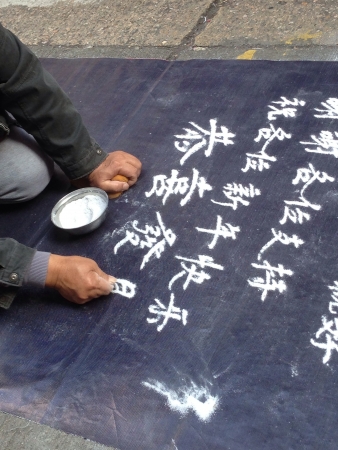 Close up of old Asian man sand writing begging for money along Tung Choi Street, Hong Kongの素材
