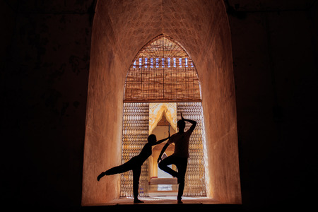 Man and woman yoga in silhouetteの写真素材
