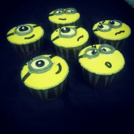 A set of cute sweet minions cupcakes on black backgroundの素材