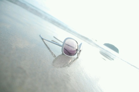 Sunglasses on a beach sand during daytimeの素材