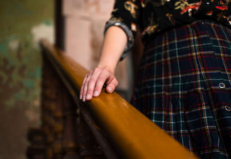 the girl goes down the stairs holding a hand for the railingの写真素材