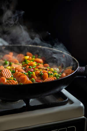 Cooking vegetables in a pan, studio lightingの写真素材