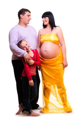 cheerful young family, a pregnant wife, a husband, a daughter. in full growth, isolated on white backgroundの写真素材