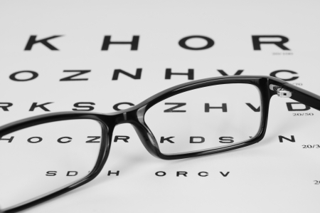 Reading eyeglasses and eye chart  close-up  on a light gray backgroundの写真素材