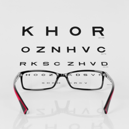 Reading Red and Black eyeglasses and eye chart  close-up  on a light gray backgroundの写真素材