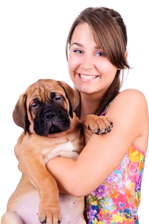 studio image of a young woman, with her bullmastiff dog, hugging it, both posing, looking happy and smilingの写真素材