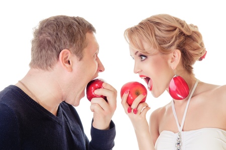 Couple in love - Caucasian man and woman eat apples. emotional portrait in the studio, isolated on white backgroundの写真素材