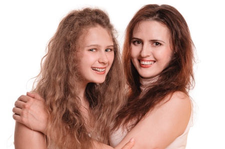 Portrait of young smiling mother with her daughter on the white backgroundの写真素材
