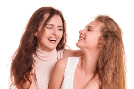 Portrait of young smiling mother with her daughter on the white backgroundの写真素材