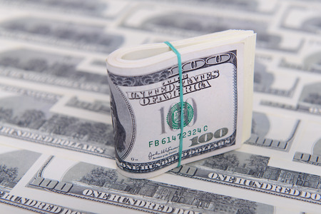 Hundred dollar bills rolled up with rubber band