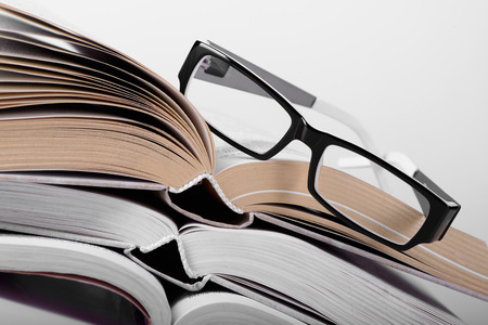 opened book with a glasses on it close-upの写真素材