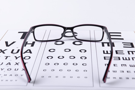 Reading black eyeglasses and eye chart close-up on a light backgroundの写真素材