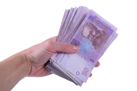 human hand holding a lot of Ukrainian hryvnia currency isolated on white