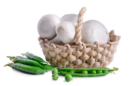 fresh mushrooms and green peas in a basket. Isolated on whiteの写真素材