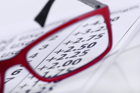 Reading red eyeglasses and eye chart close-up on a light backgroundの写真素材