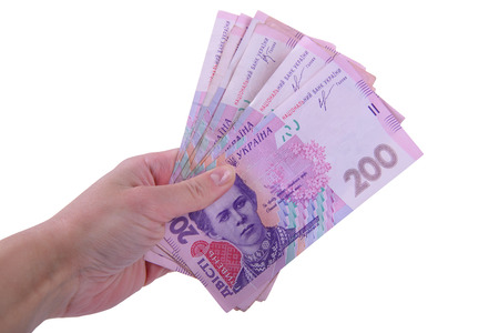 human hand holding a lot of Ukrainian two hundred hryvnia currency isolated on white