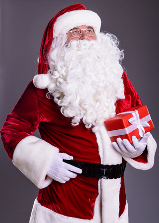 happy Santa Claus with giftbox on gray backgroundの写真素材