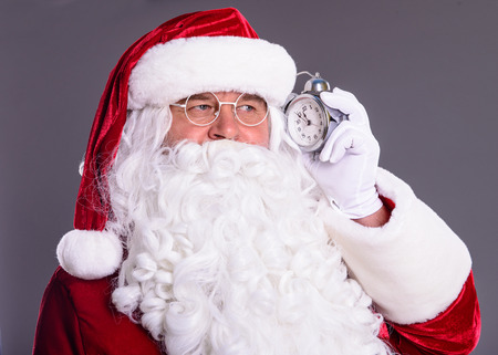 happy Santa Claus with clock on gray backgroundの写真素材