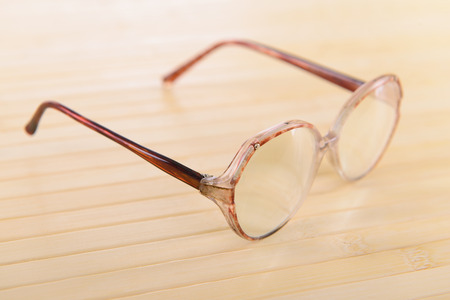 reading old glasses. close-up. on a light wooden backgroundの写真素材