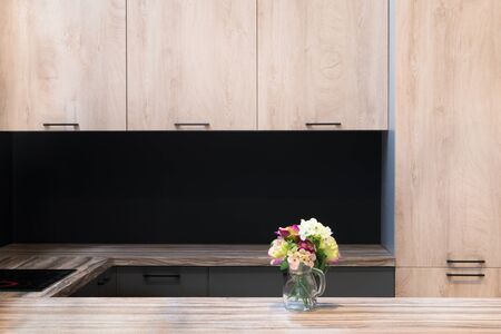 Modern kitchen room interior with furniture and flowers on counter for a concept design - light home backgroundの写真素材