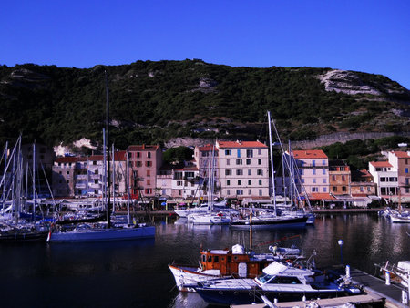 Scenic View of Bonifacio Port in Corsica with Luxury Yachts and Cliffside Town Experience the charm of the French island of Corsica with this stunning image capturing the picturesque port of Bonifacioの写真素材