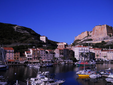Scenic View of Bonifacio Port in Corsica with Luxury Yachts and Cliffside Town Experience the charm of the French island of Corsica with this stunning image capturing the picturesque port of Bonifacioの写真素材