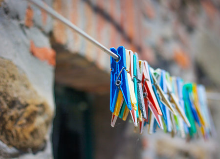 Colorful clothespin clothespins on the hangers. Plastic clothespins in different colors on the background of a brick, antique wall.の写真素材