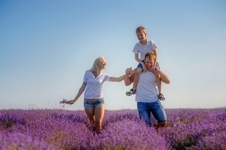 Happy family in a field of lavender on sunset.の写真素材