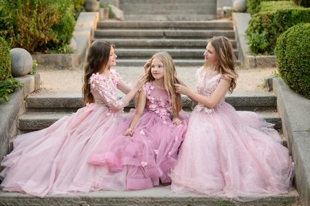 Beautiful young girls in amazing dress outdoor. Children bridesmaids