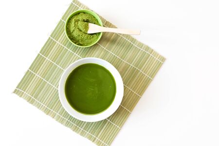 Wooden spoon with powdered matcha green tea in bowl, isolated on white background.の写真素材