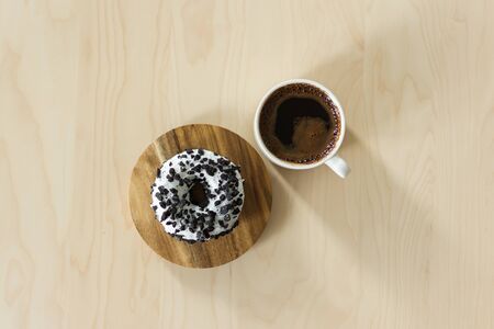 Coffee and donut for breakfast. Cup of dark espresso with sweet donut dessert.の写真素材
