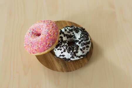 Donuts with icing on wooden background top view. Sweet donuts dessert. Copy space.の写真素材