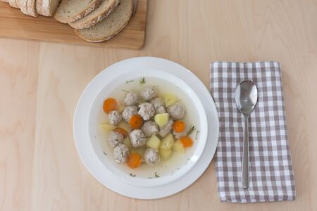 Soup with meatballs and vegetables on the table top view. Bowl of soup with meat. Healthy eating.の写真素材