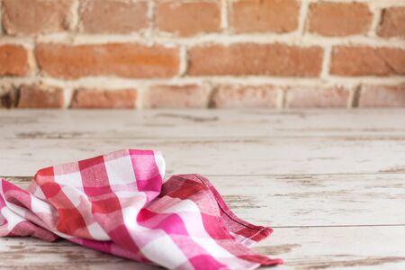 Red checkered napkin on wooden background Background with napkin, template for design.の写真素材