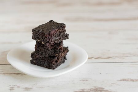 A stack of chocolate brownies on wooden background, homemade bakery and dessert.の写真素材